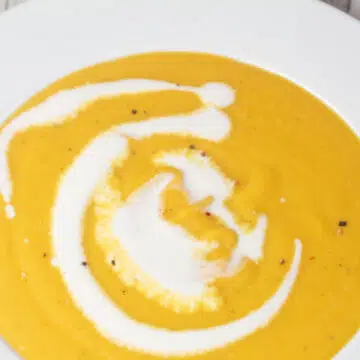 Wide image of a large bowl of butternut squash soup.