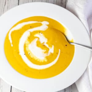 Square image of a large bowl of butternut squash soup.