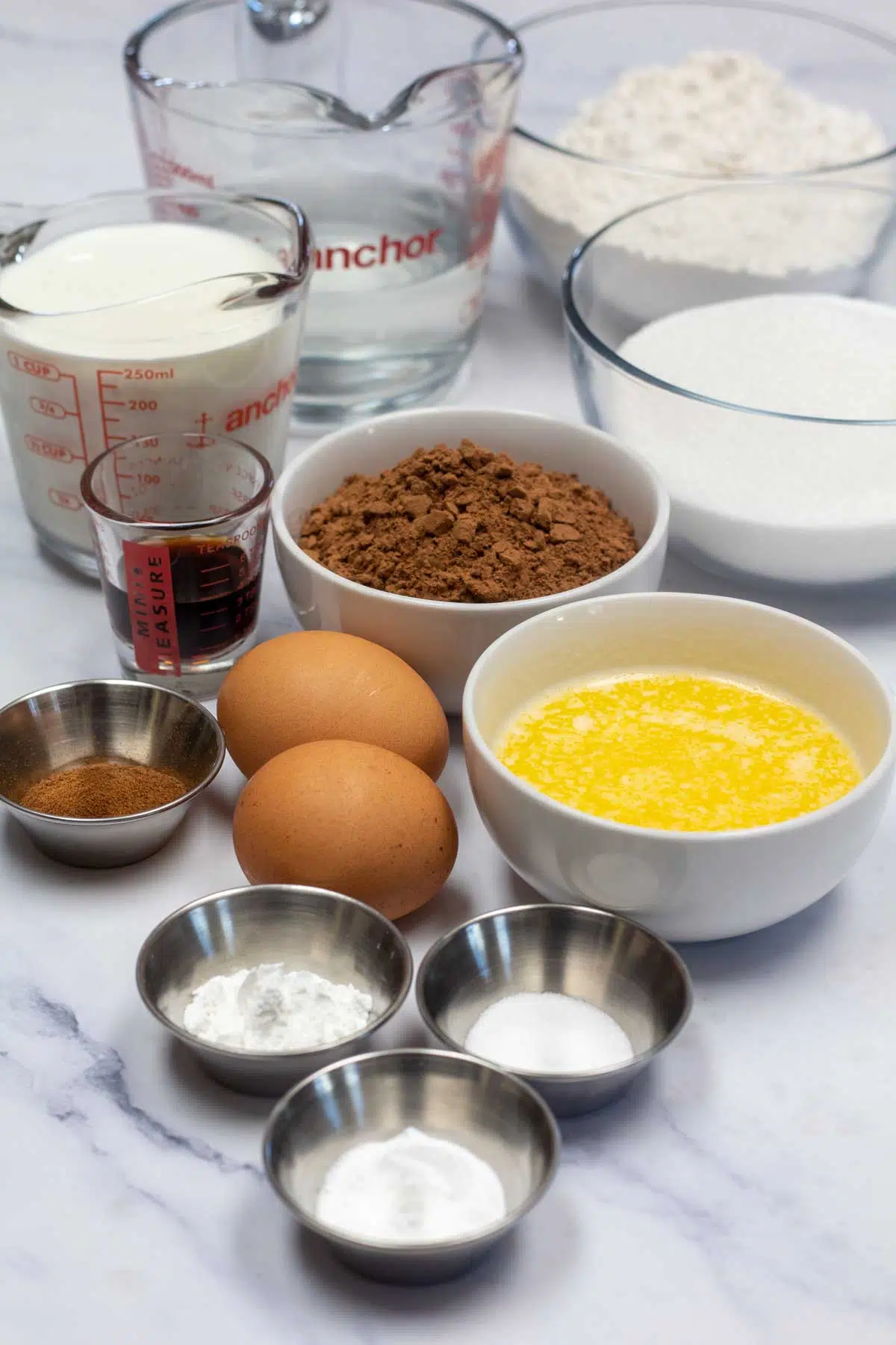 Tall image of ingredients needed for easy chocolate cake.