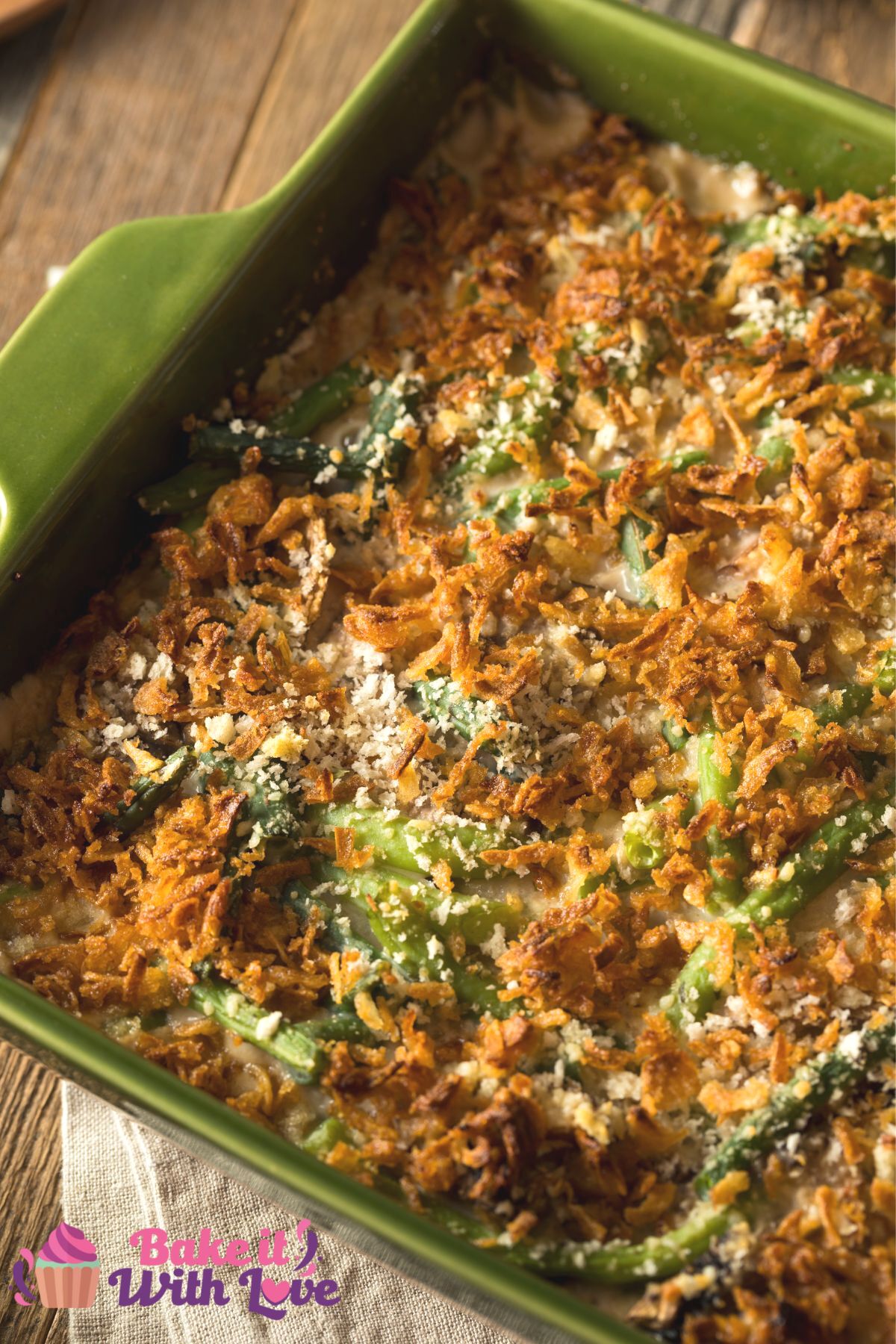 Tall image of green bean casserole on a green baking dish.