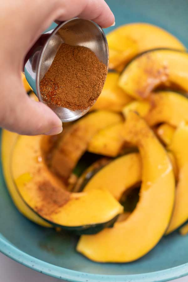Process image 4 showing acorn squash in a bowl and adding spices.