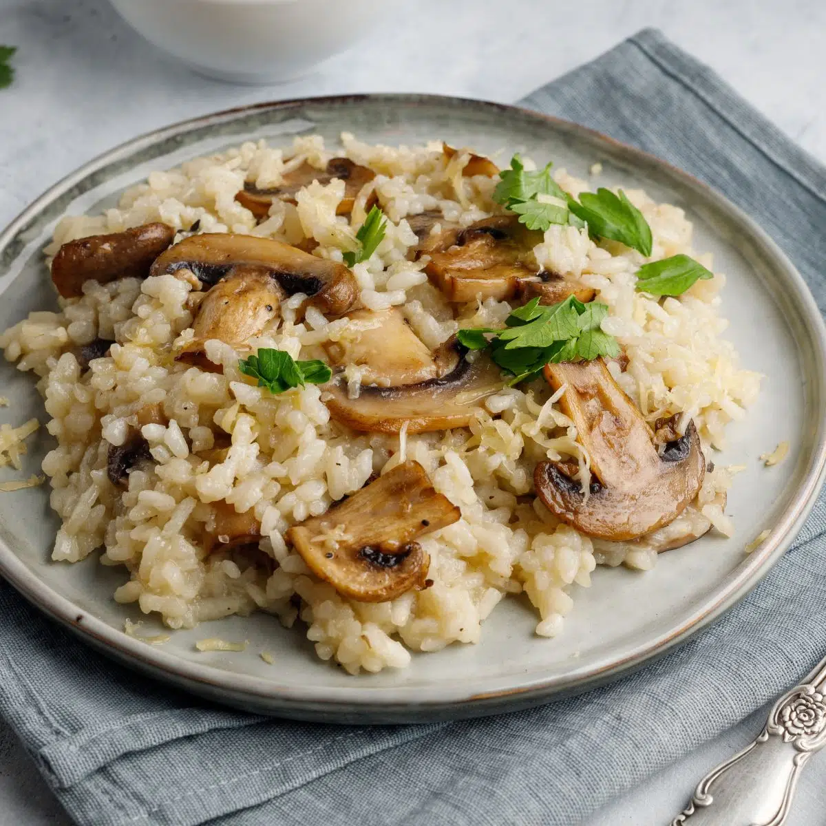 Square image showing a plate of mushroom risotto.
