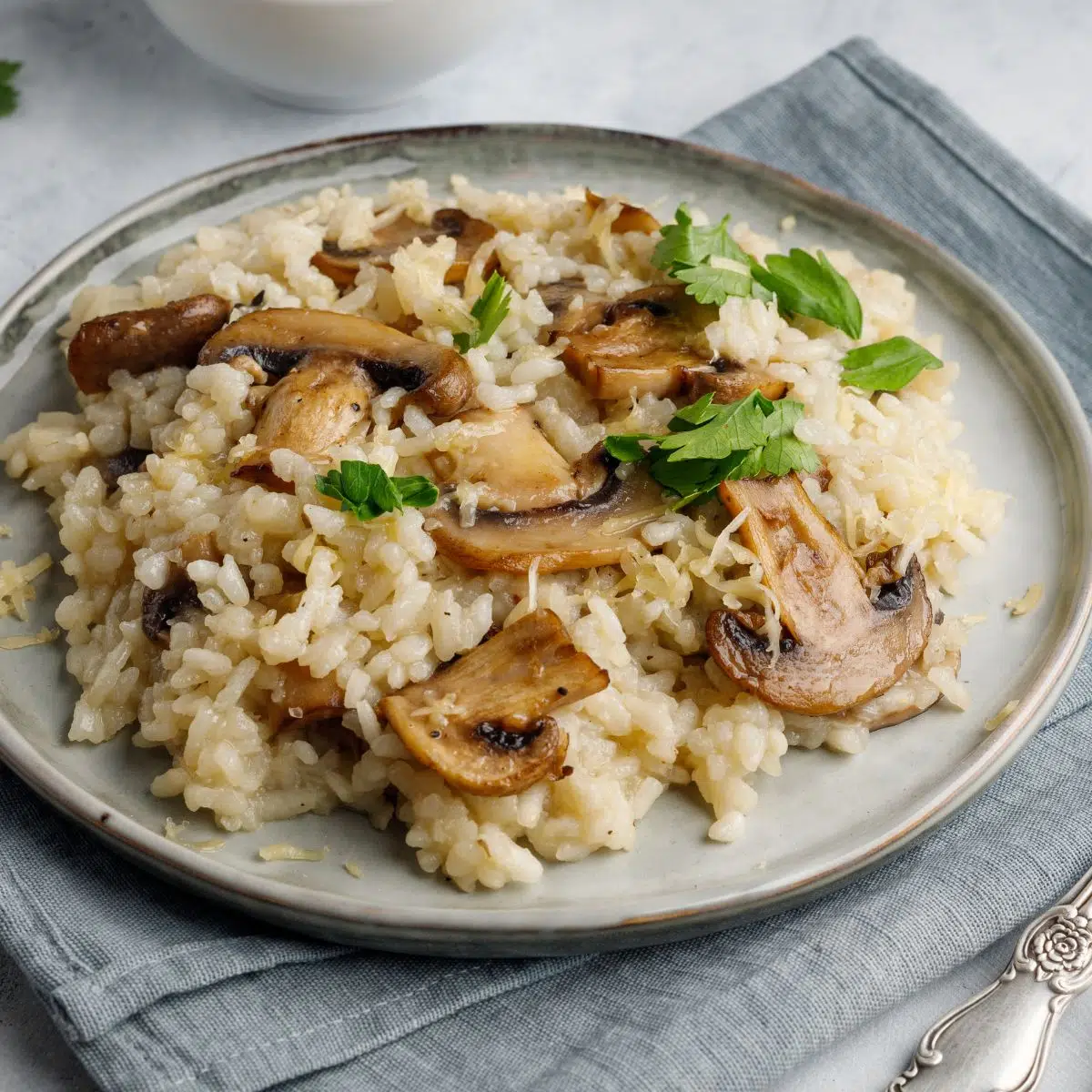 Imagen cuadrada que muestra un plato de risotto de champiñones.