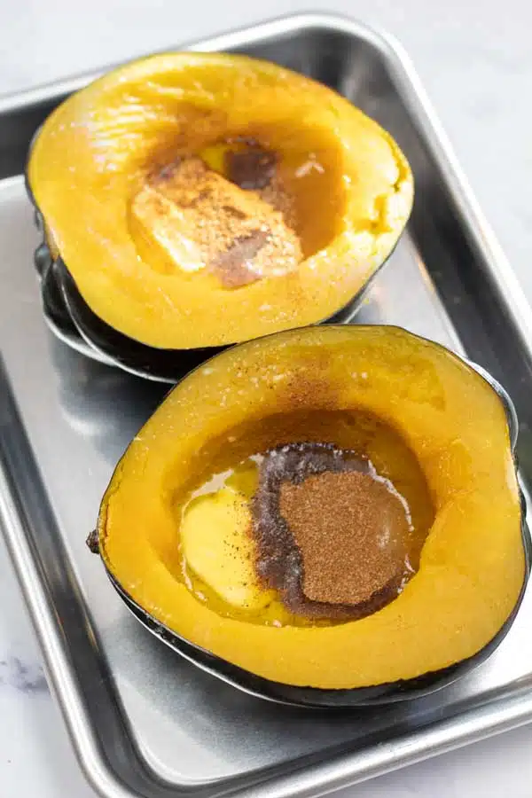 Process image 4 showing placing acorn squash on a baking sheet with butter, honey, and spices.