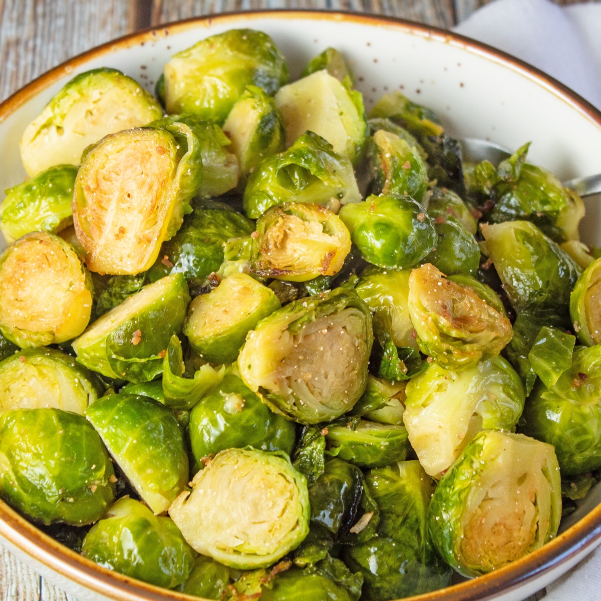 Square image of pan seared brussel sprouts in a large bowl.
