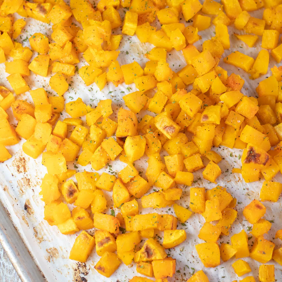 Square image of roasted butternut squash on a baking sheet.