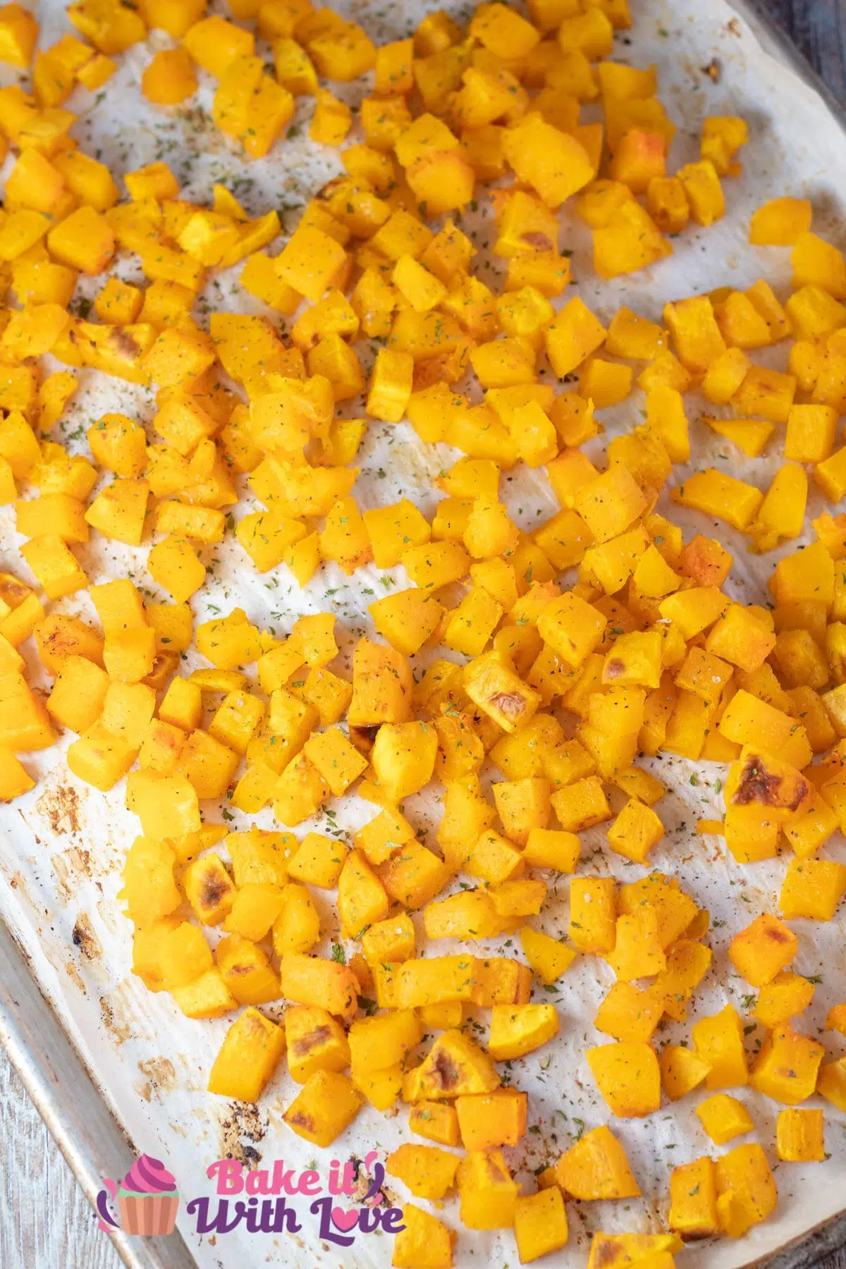 Tall image of roasted butternut squash on a baking sheet.