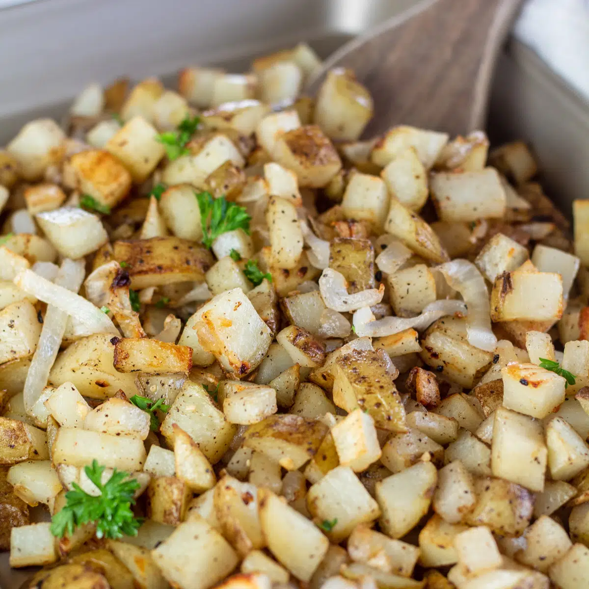 Square image showing roasted potatoes and onions.
