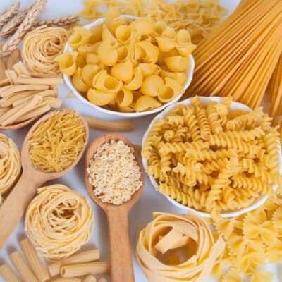 Square image of a variety of pasta on a white background.