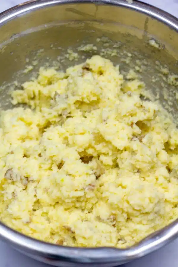 Process image 6 showing combining butter to riced potatoes.