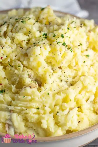 Tall image showing a large bowl of yellow mashed potatoes.