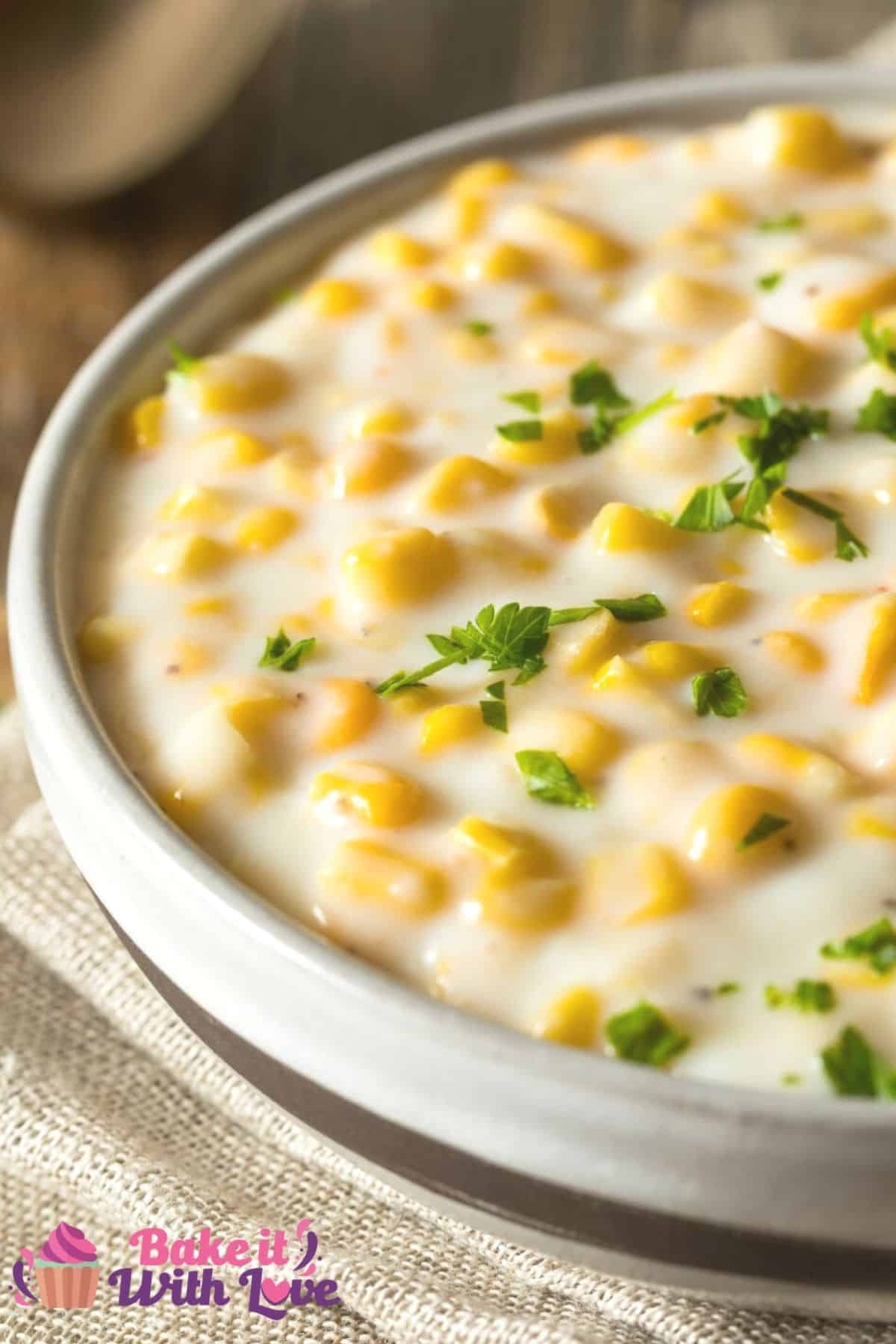 Tall closeup on the easy homemade creamed corn in bowl garnished with chopped fresh parsley.