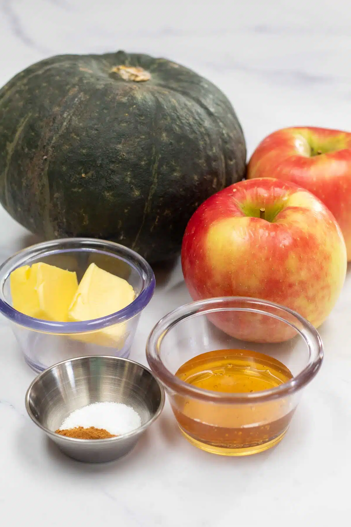 Tall image of ingredients needed for baked buttercup squash with apples.