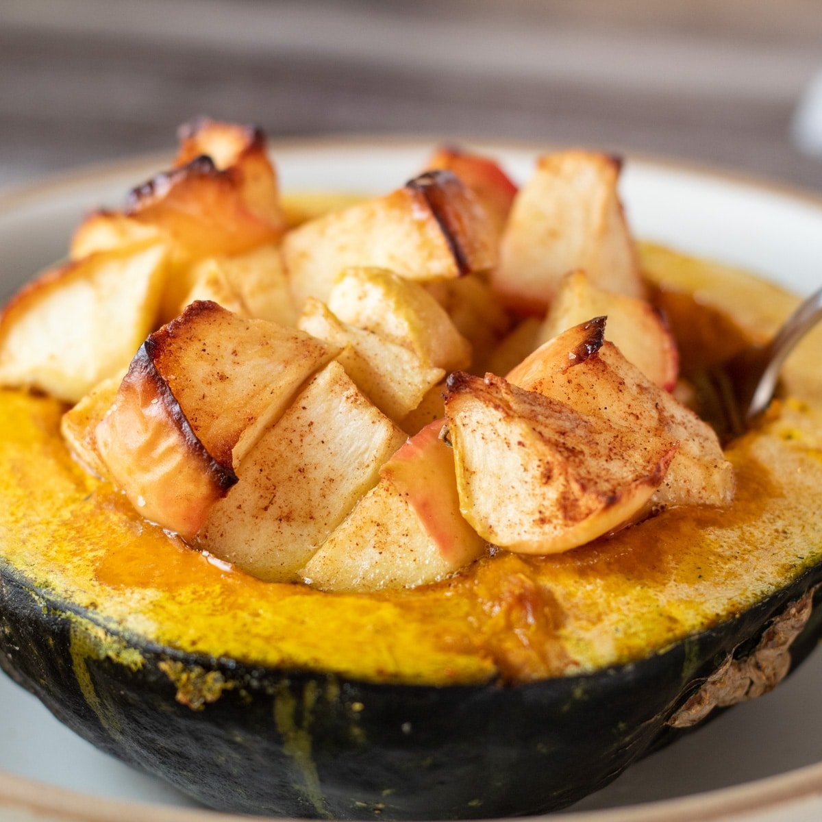 Square image of baked buttercup squash with apples.