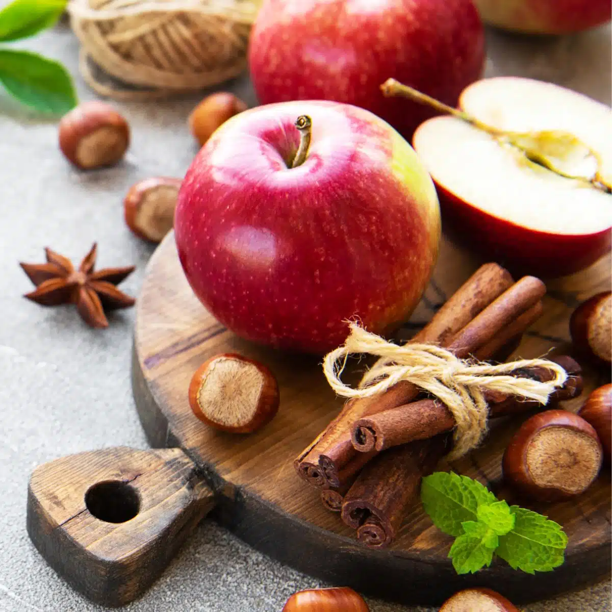 Immagine quadrata di una mela con altri ingredienti da forno e da cucina.