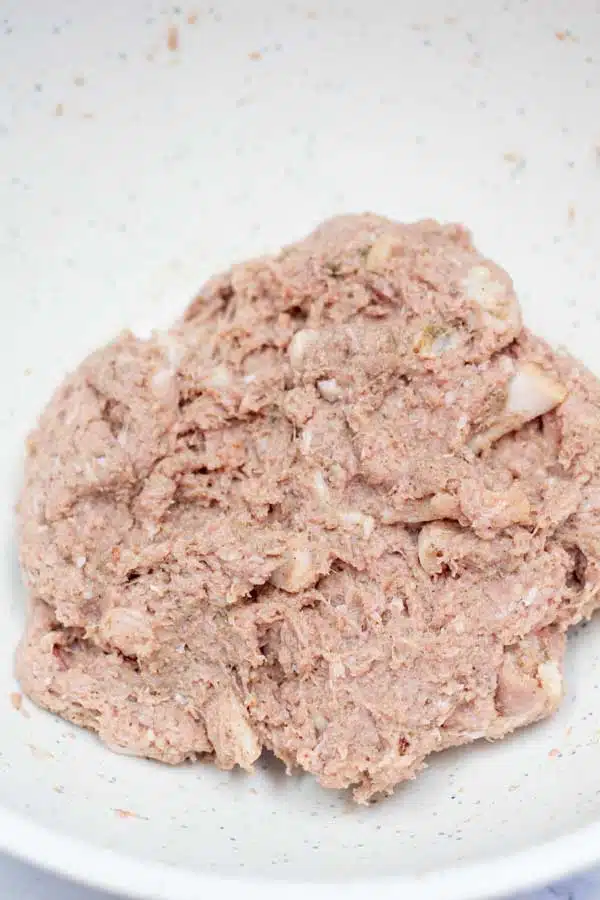 Process image 2 showing chopped bacon, ground pork, and seasoning combined in a mixing bowl.