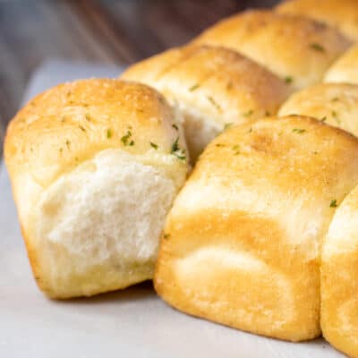 Square image of butter herb Rhodes rolls.