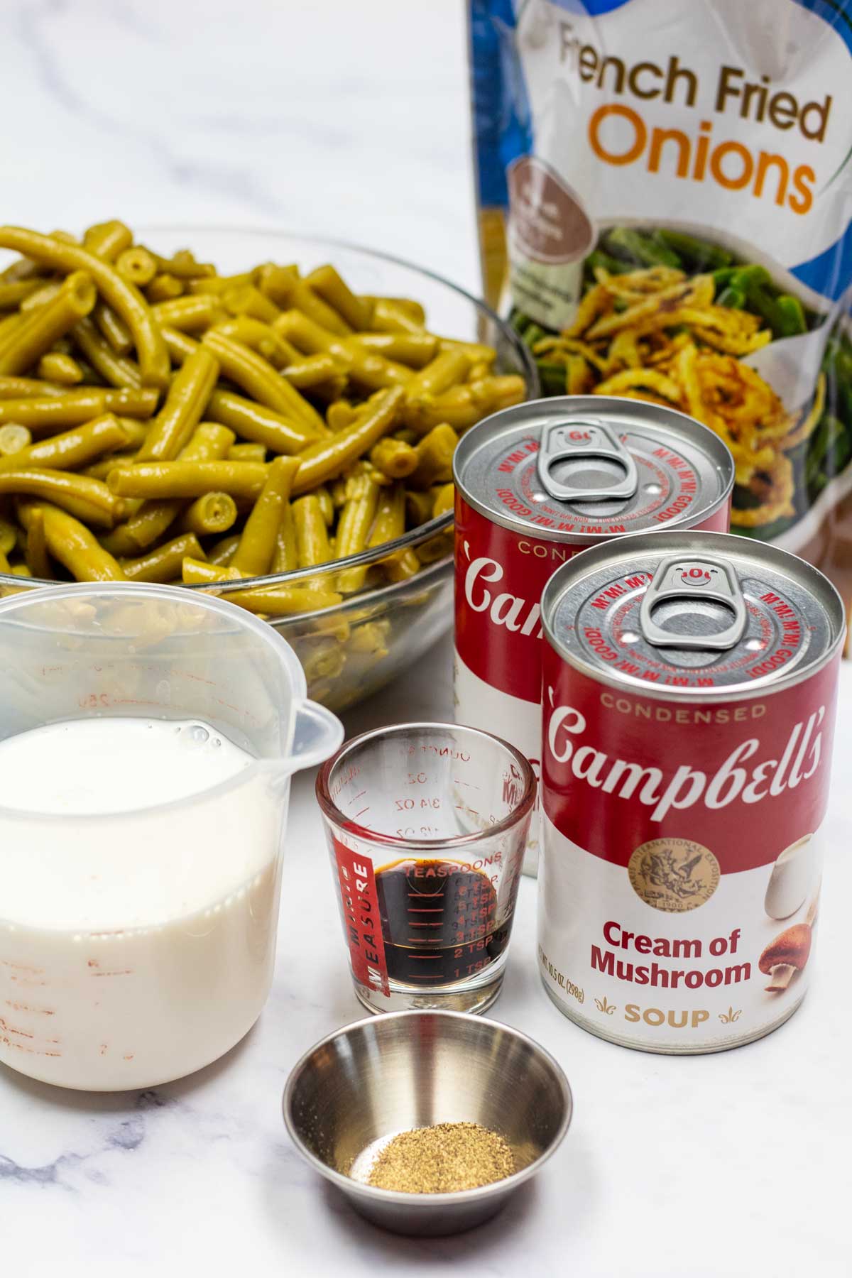 Tall image showing all the ingredients needed for Campbell's green bean casserole.
