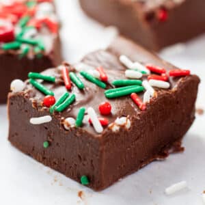 Close up square image of Christmas fudge with sprinkles.
