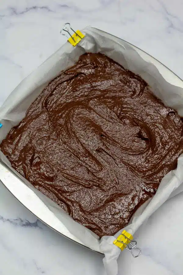 Process image 9 showing brownie batter in a 8x8 baking dish.