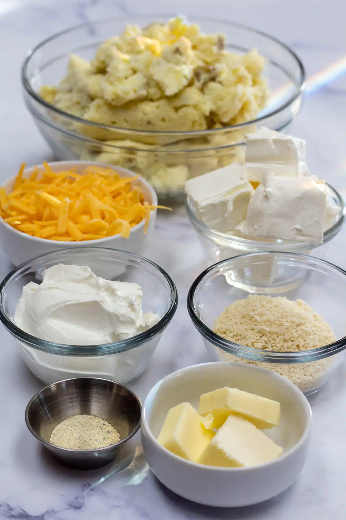 Tall image showing ingredients needed for mashed potato casserole.