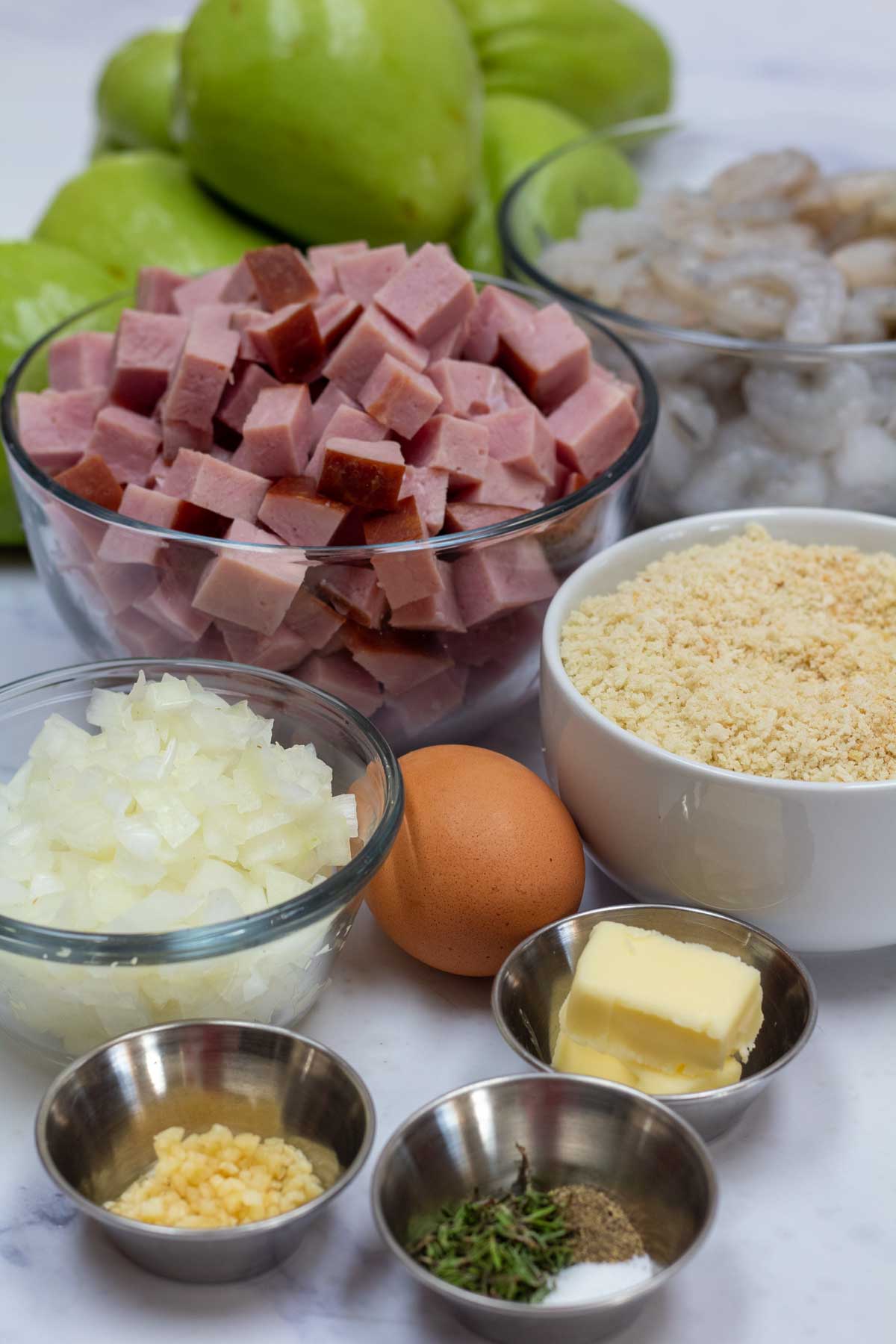 Tall image showing ingredients for this Cajun mirliton recipe.