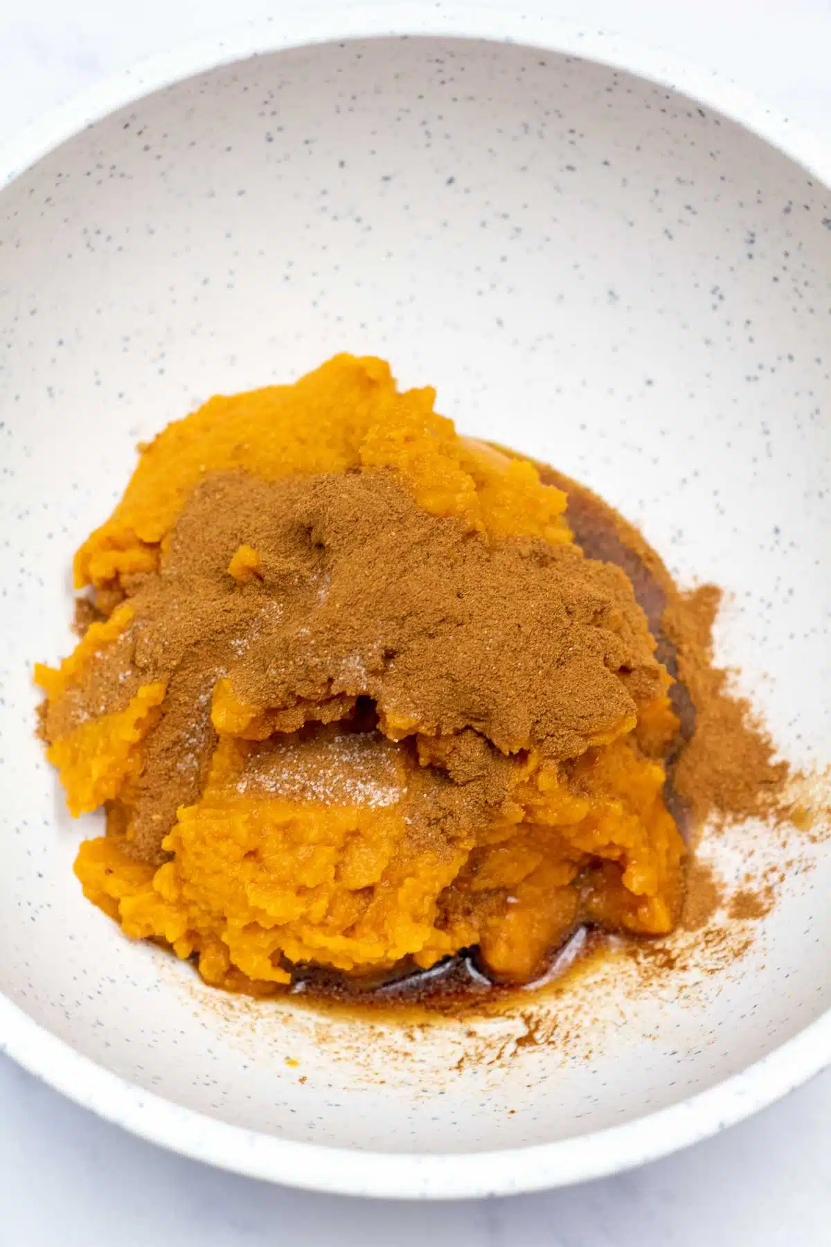 Process image 1 showing pumpkin puree and spices in a mixing bowl.