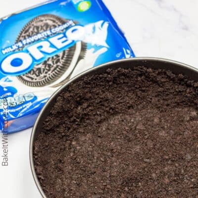 Pin image with text of oreo cookie crust in a springform pan.