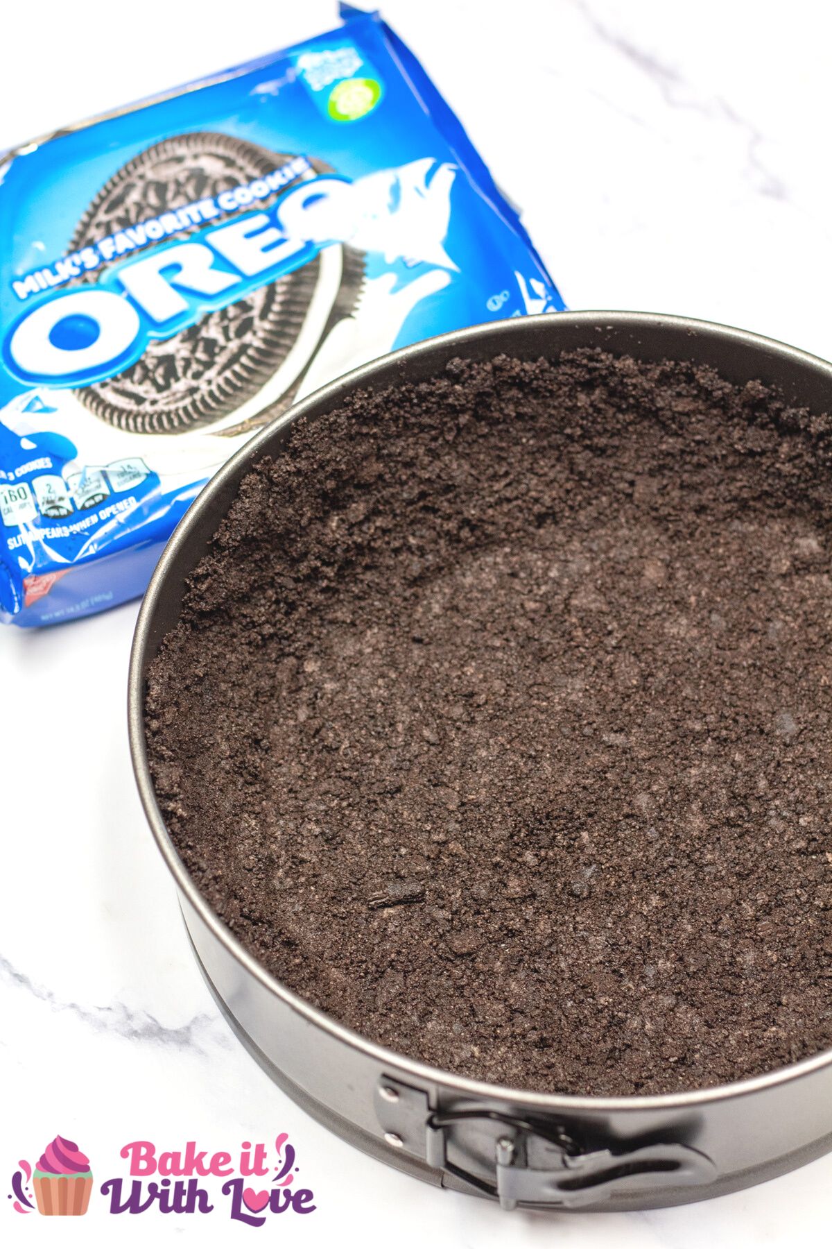 Tall image of oreo cookie crust in a springform pan.