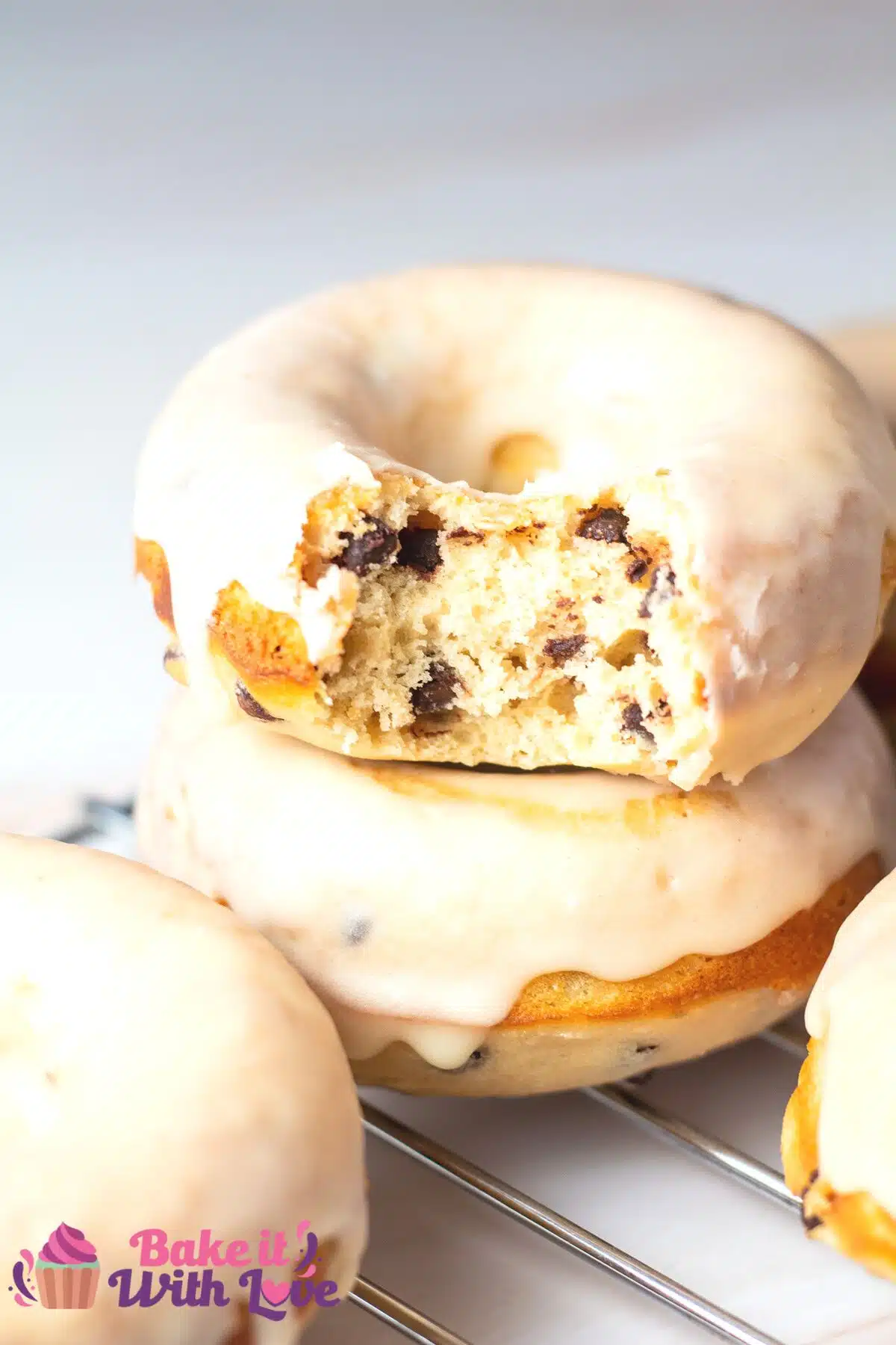 Tall image of peanut butter & chocolate chip baked donuts.