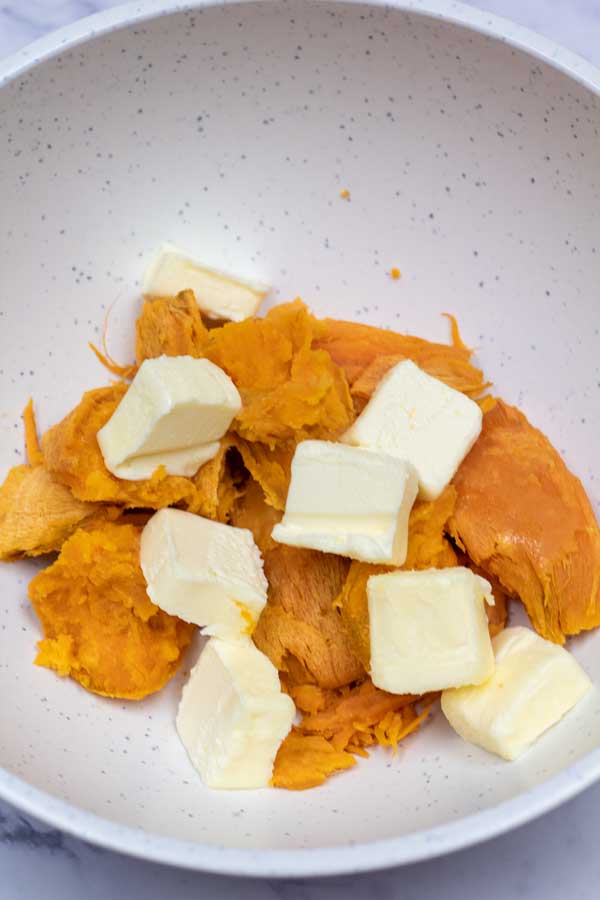 Process image 1 showing softened sweet potatoes and butter in a mixing bowl.