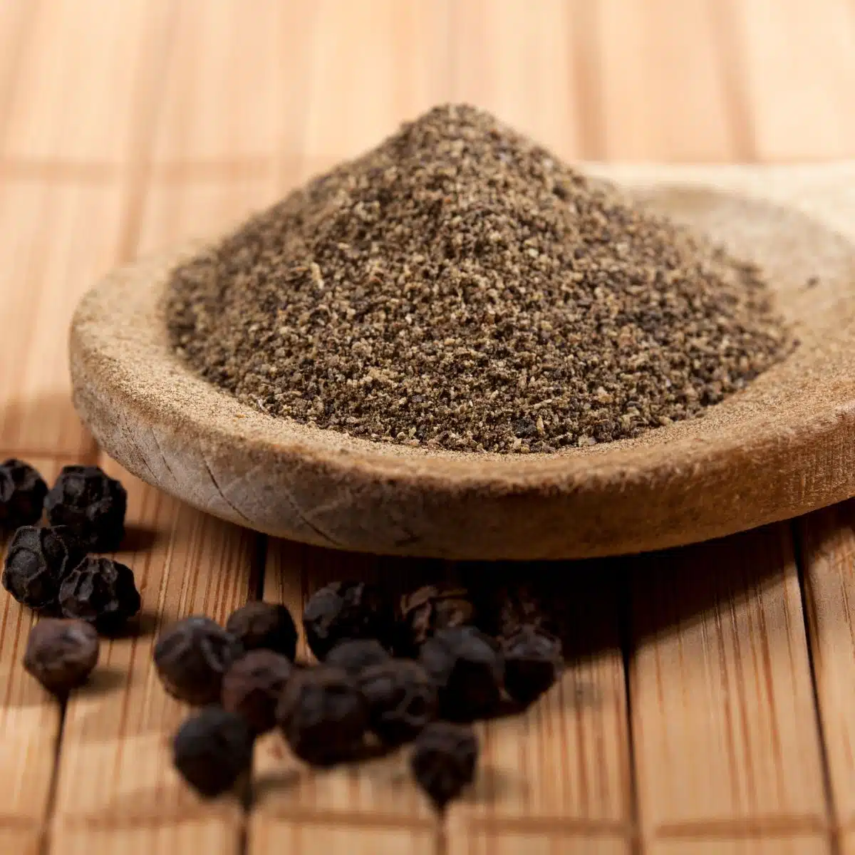 Square image of black pepper in a small dish.