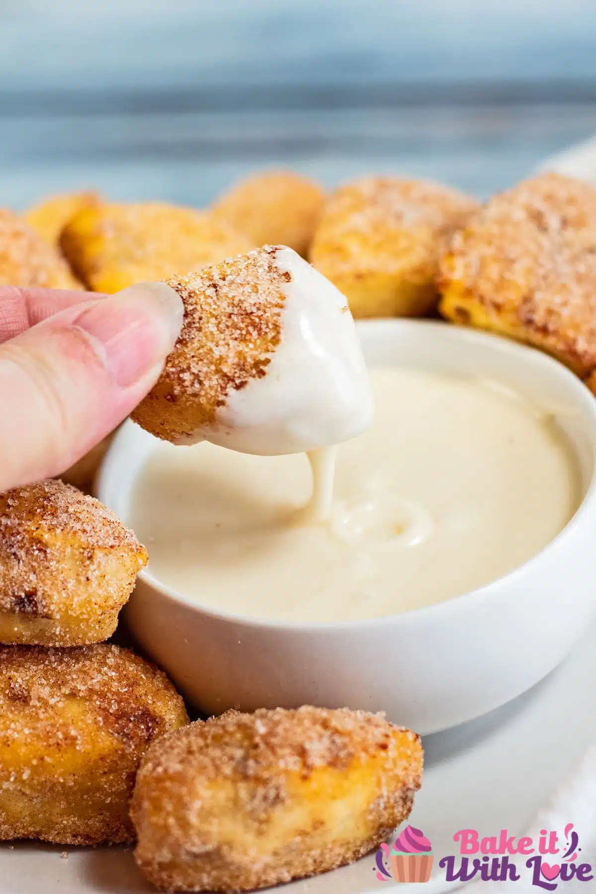 Best air fryer cinnamon roll bites recipe being dipped into the perfectly tasty vanilla dipping sauce.