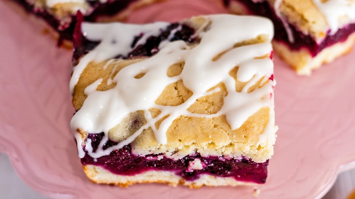 Closeup on the baked, iced, and sliced blueberry pie bars.