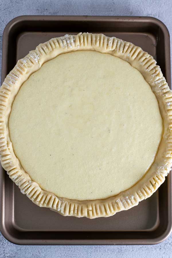 Immagine di processo 7 che mostra il ripieno di crema pasticcera in una crosta di torta.