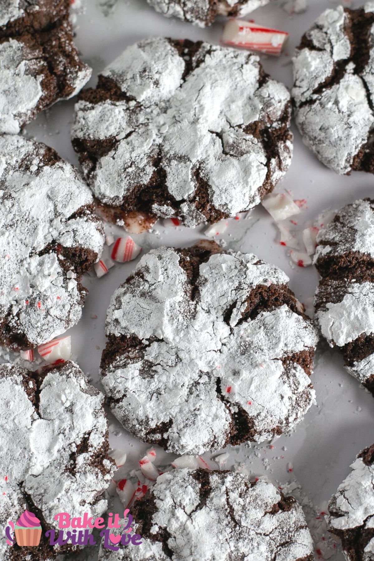 Overhead of the baked chocolate peppermint crinkle cookies on marble surface with crushed candies.