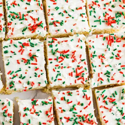 Best Christmas sugar cookie bars to slice and serve with festive holiday sprinkles on a tasty vanilla buttercream frosting.