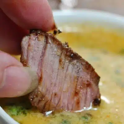 Best cowboy butter recipe pin with text header and image of steak dipping into the butter sauce.