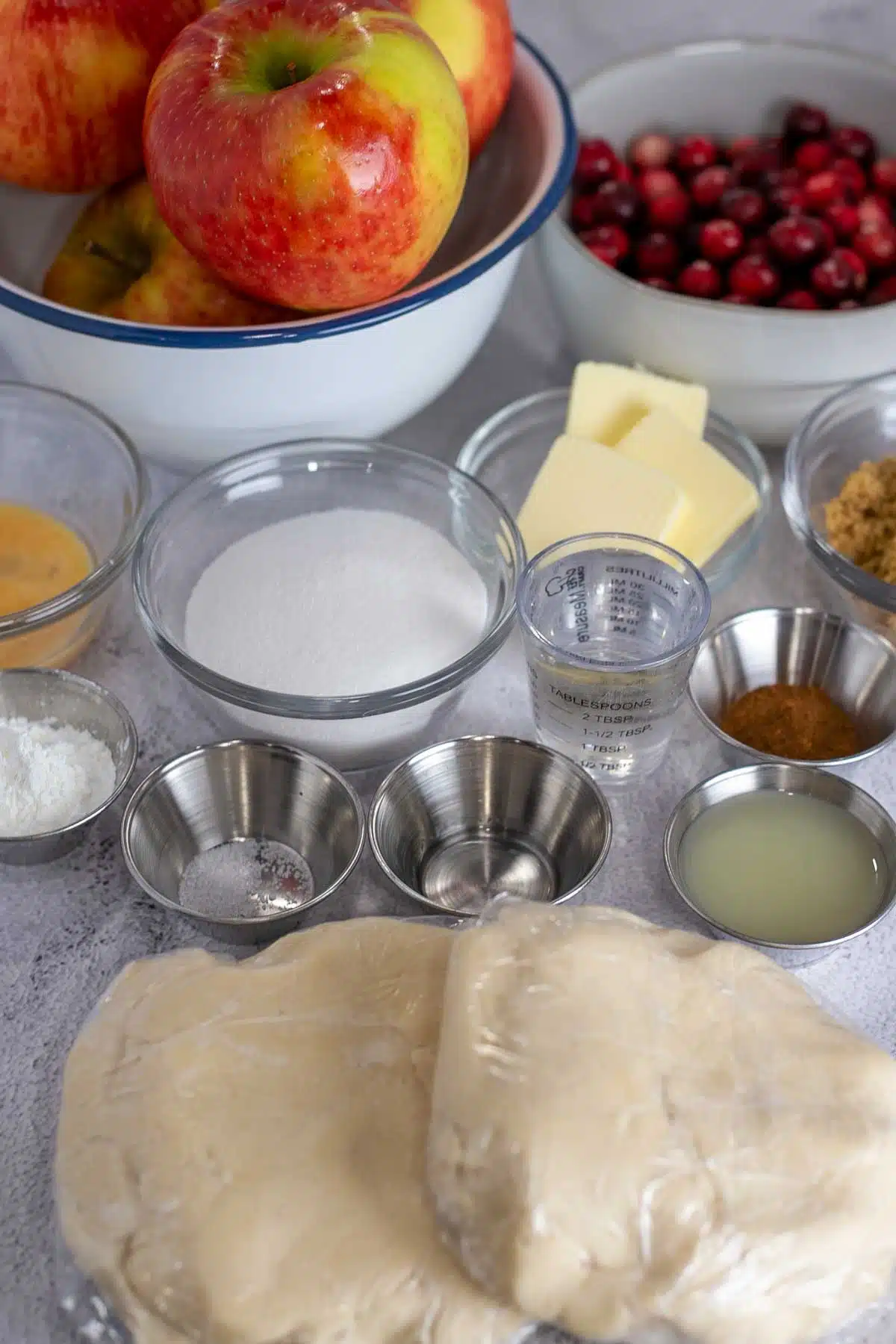 Tall image showing apple and cranberry pie ingredients.