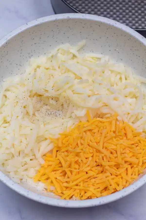Process image 1 showing hashbrowns and cheese in a mixing bowl.