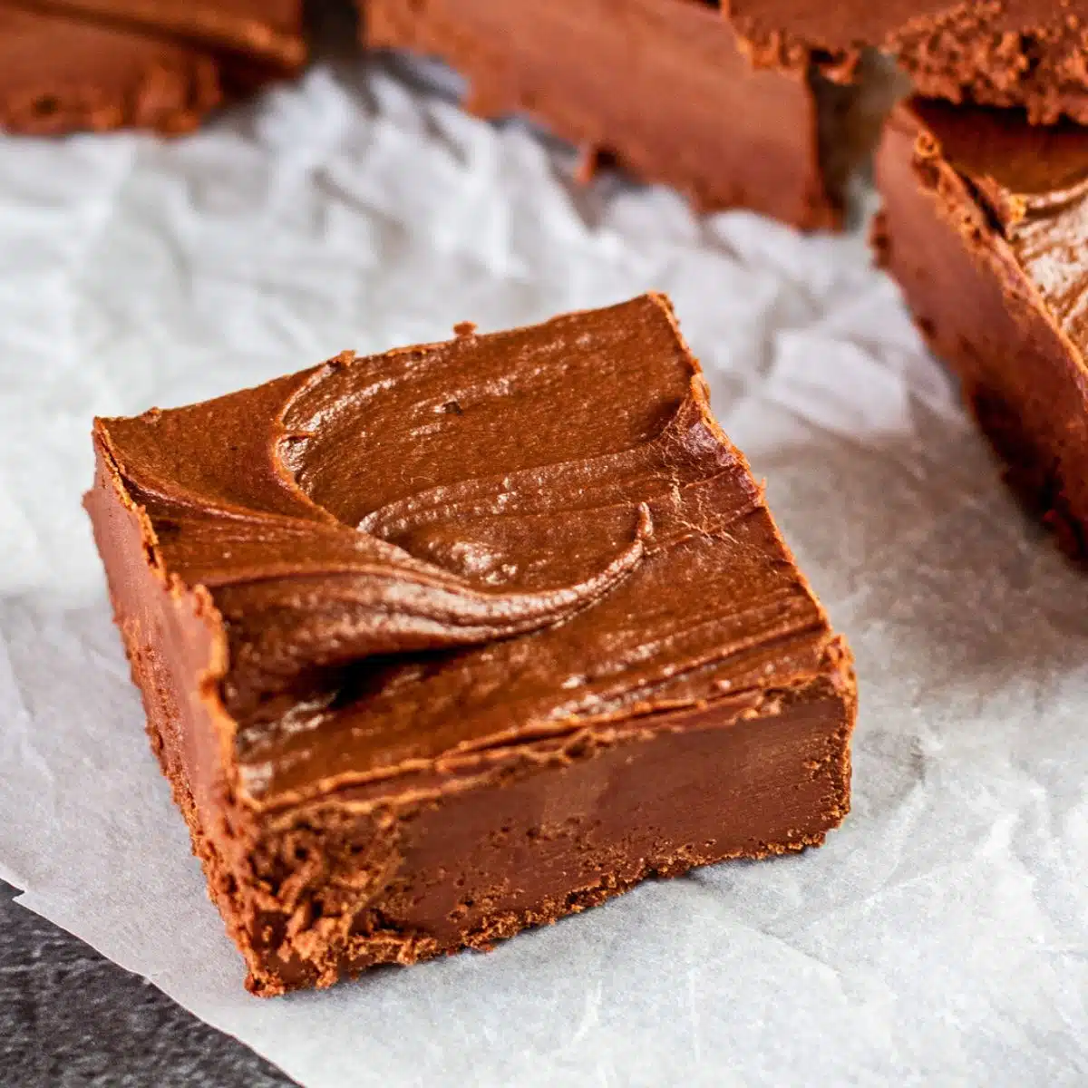 Square image showing fudge on a white plate.