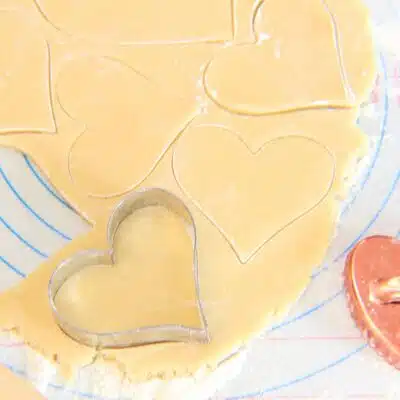 Square image showing cookie dough and heart cut out.