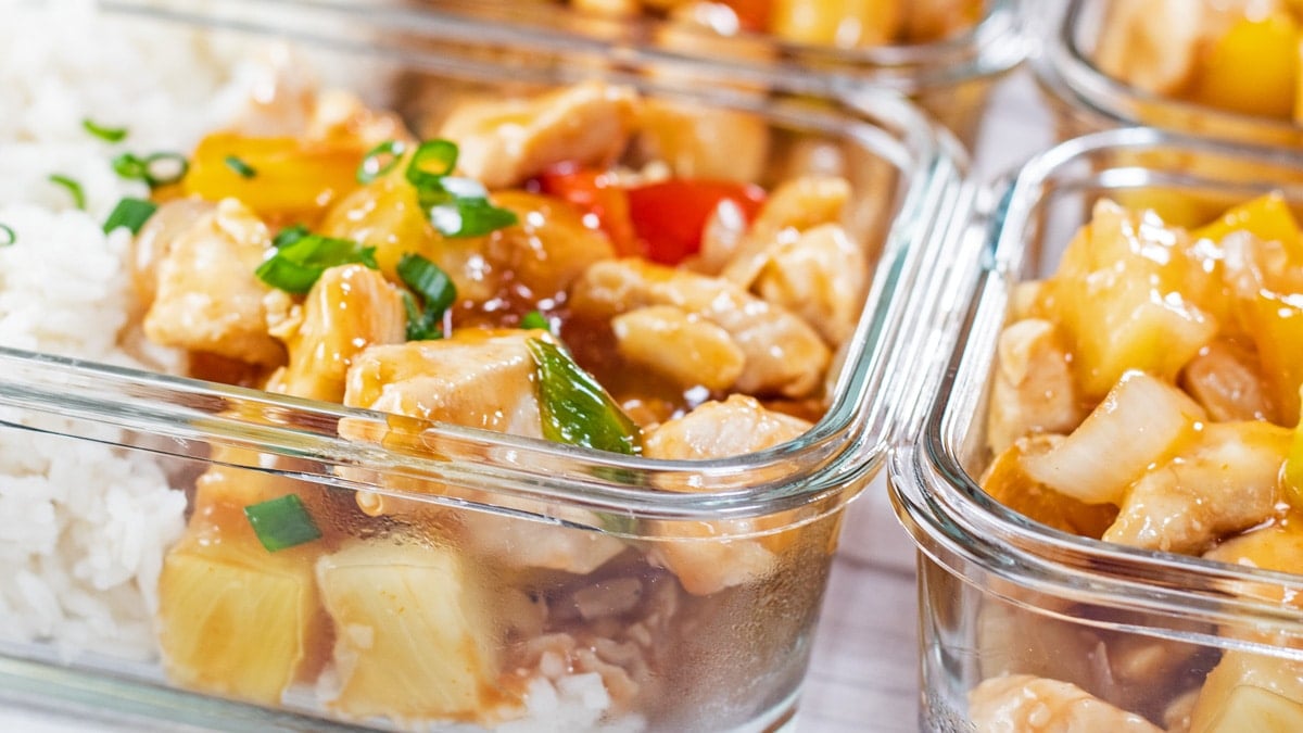 Wide closeup on the meal prep sweet and sour chicken in glass storage containers.