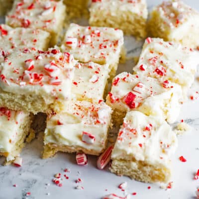 Best peppermint sugar cookie bars to bake up for the holidays with their creamy vanilla frosting and crushed candy cane topping.