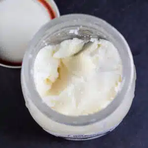 What is tallow shown with an opened jar of tallow on dark background.