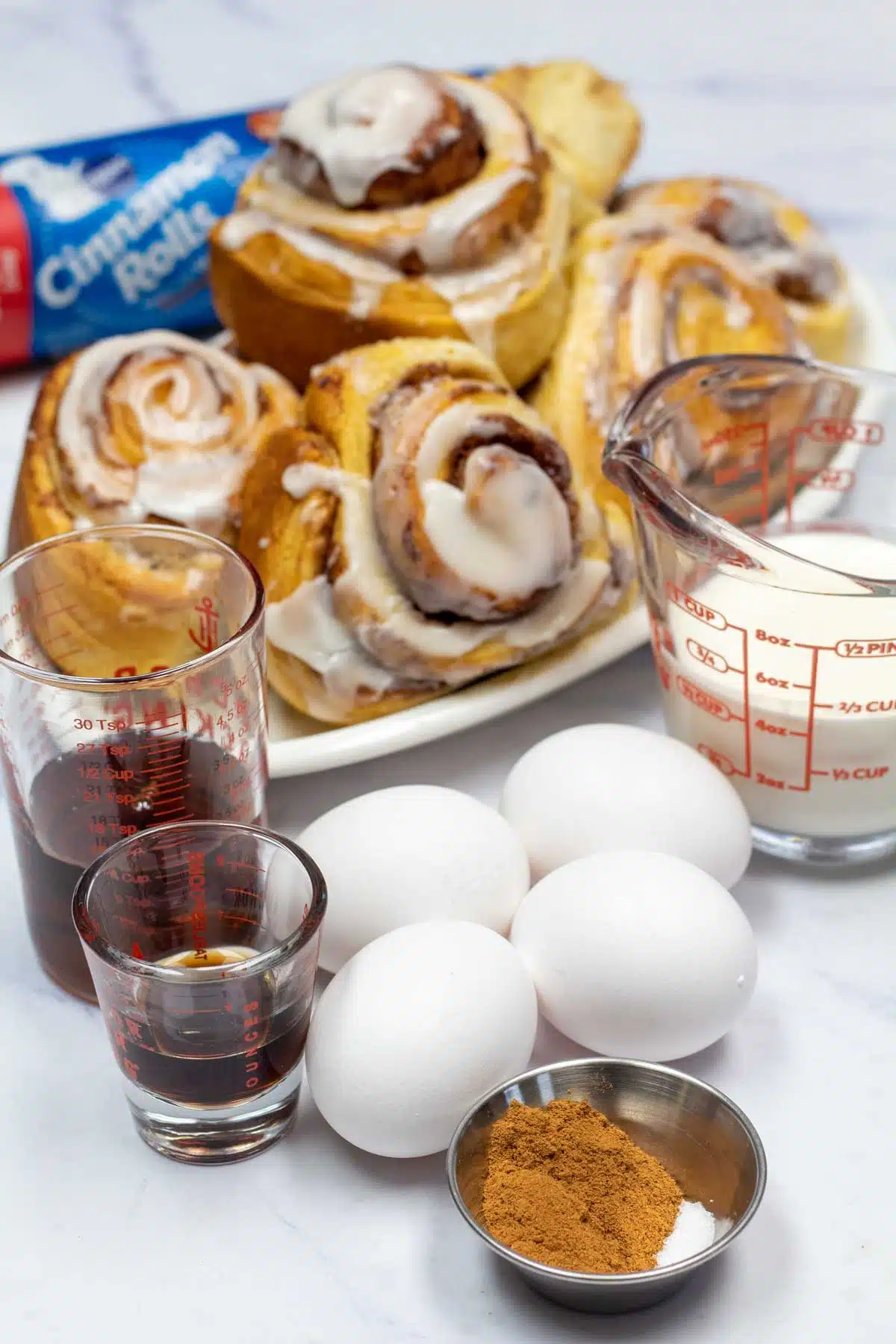 Tall image showing cinnamon roll breakfast casserole ingredients.