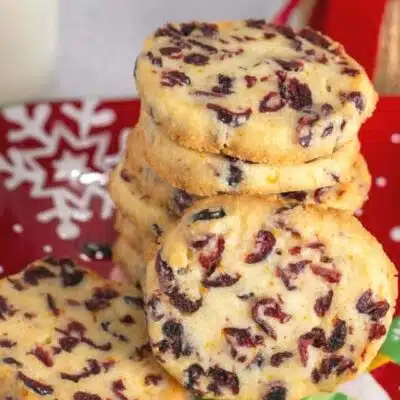 Tall image with text showing cranberry orange shortbread cookies.