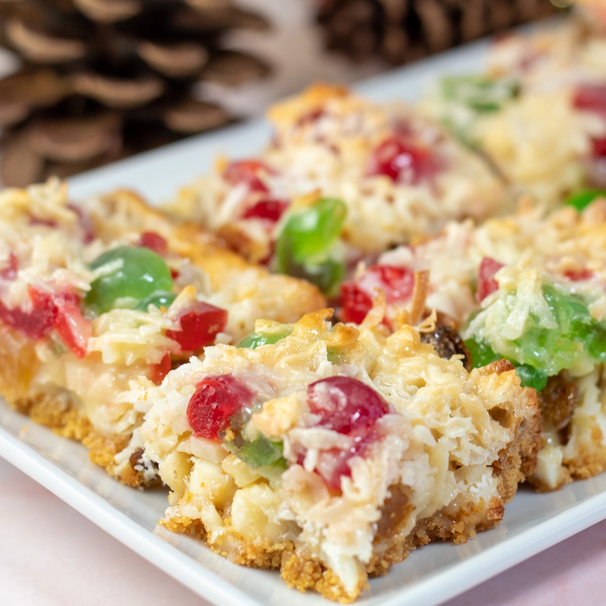 Square image showing fruitcake magic bars on a serving tray.