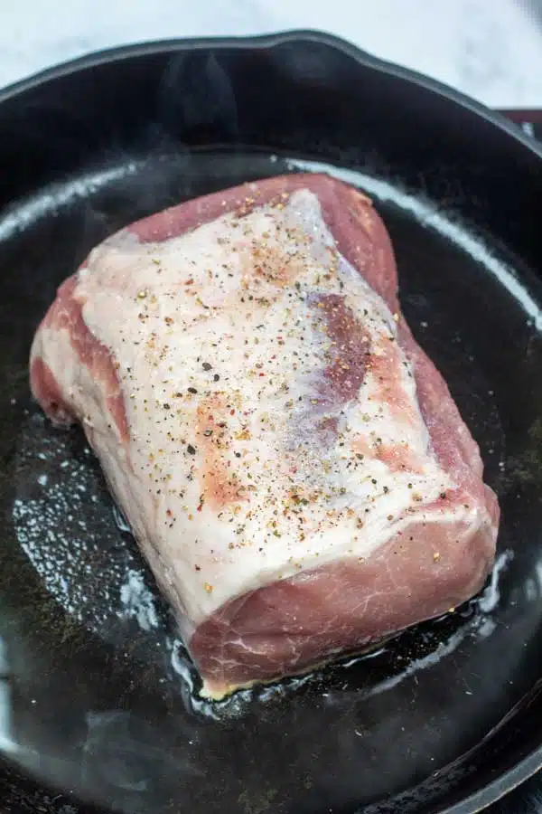 Process image 2 showing pork ribeye roast searing in cast iron pan.