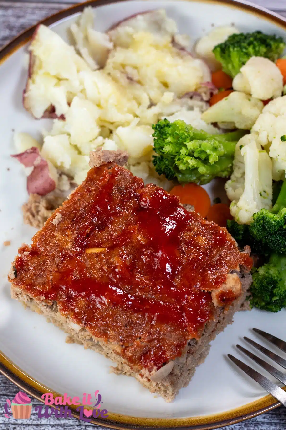 Tall image of a slice of turkey meatloaf on a white plate.